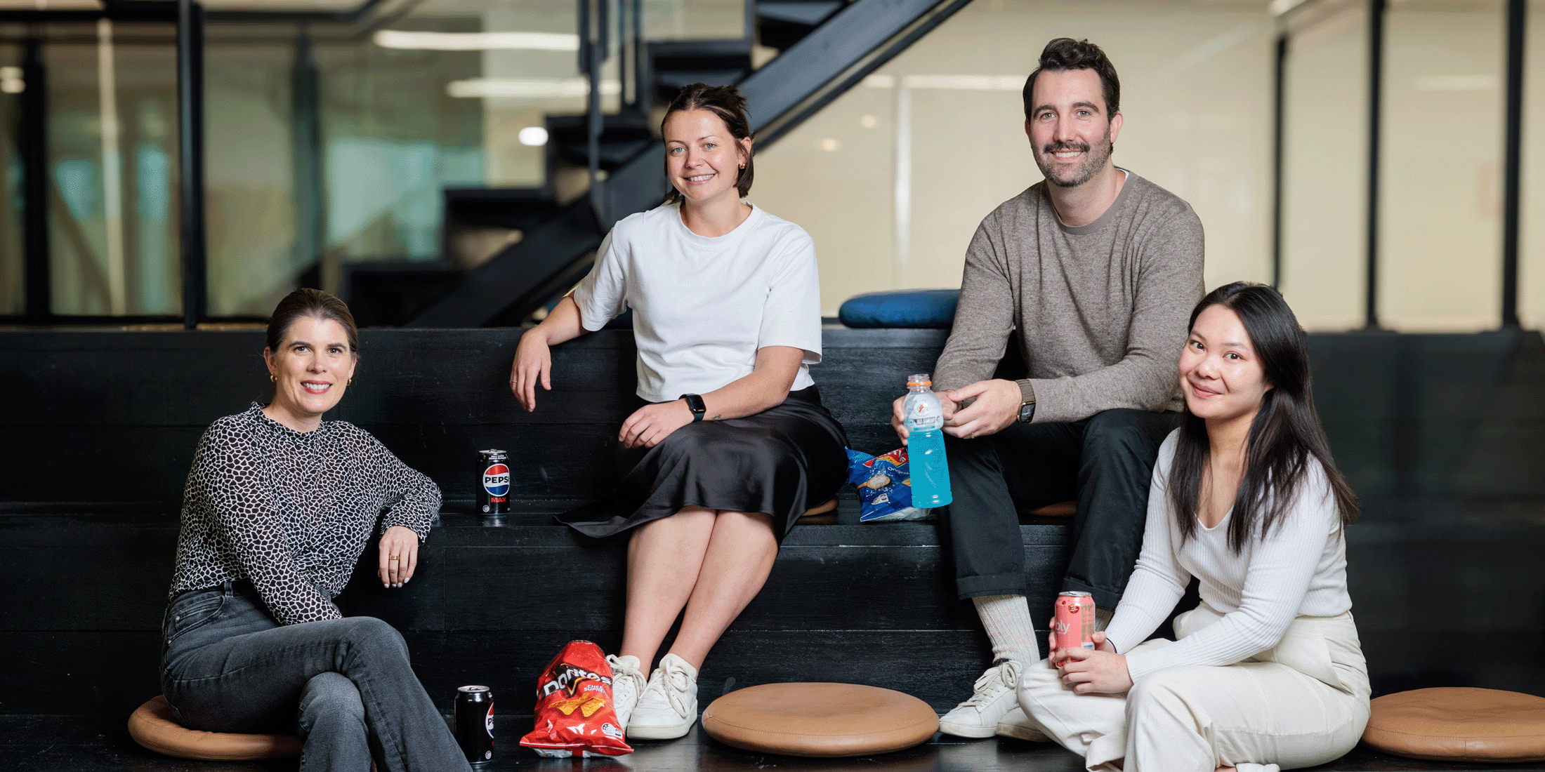 Employees enjoying PepsiCo products while sitting around couches