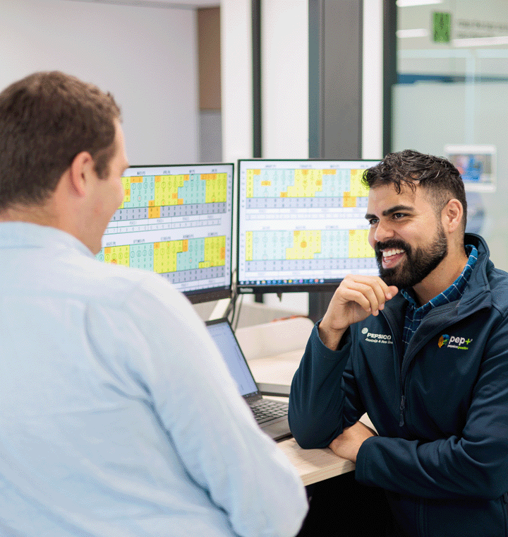 Two employees discussing near a computer