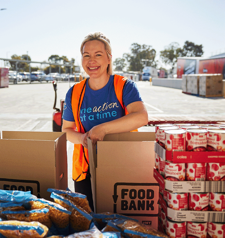 Woman wearing One Smile at a Time shirt helping at a food bank